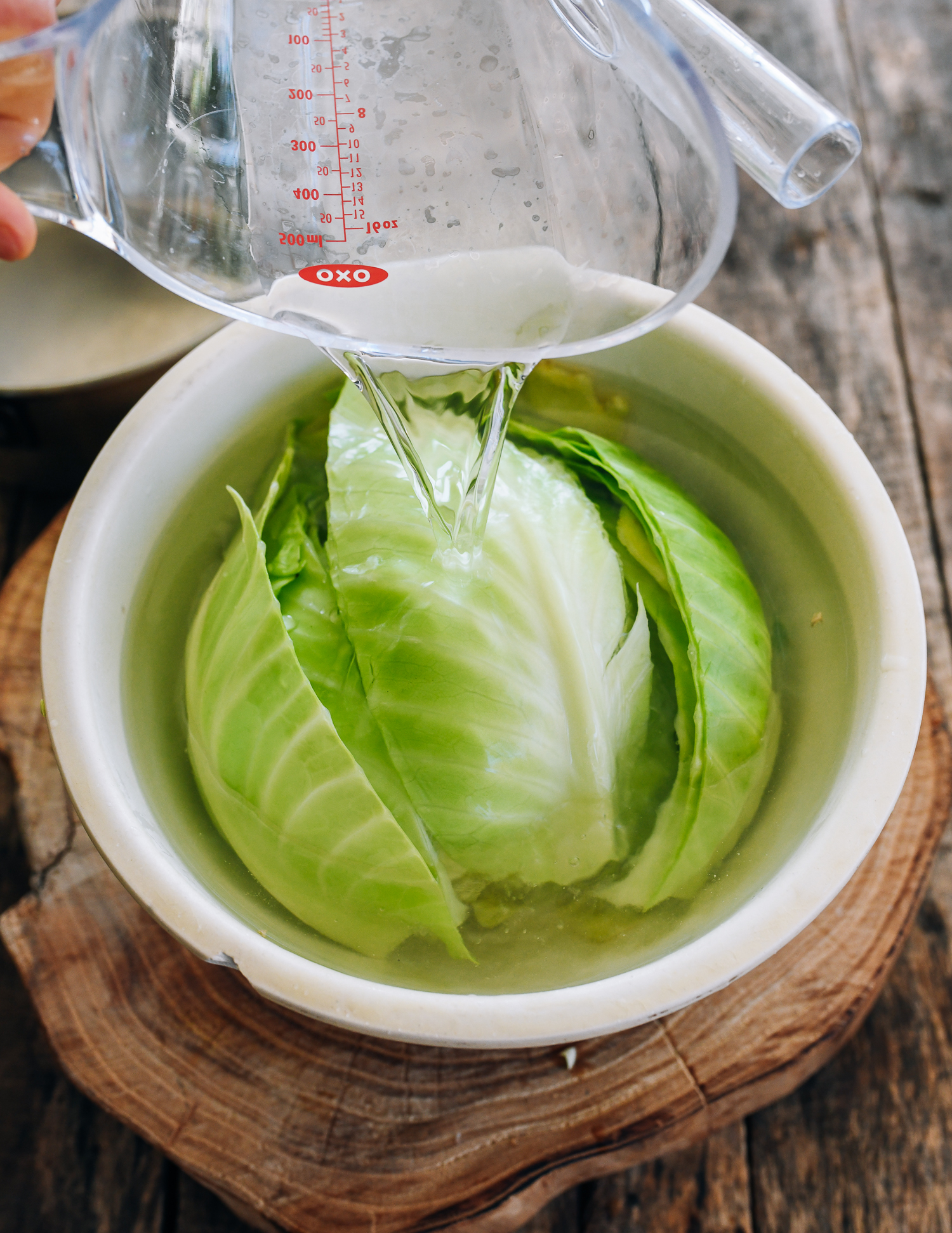 pouring vinegar over cabbage in bowl