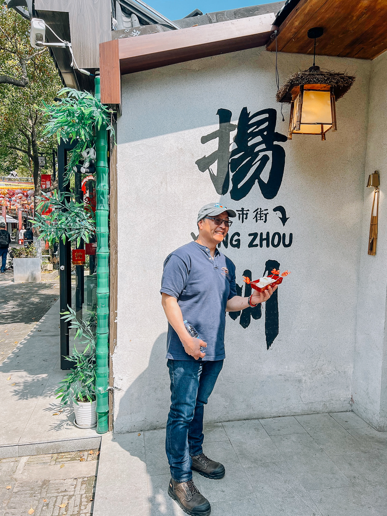 Bill in front of Yangzhou sign
